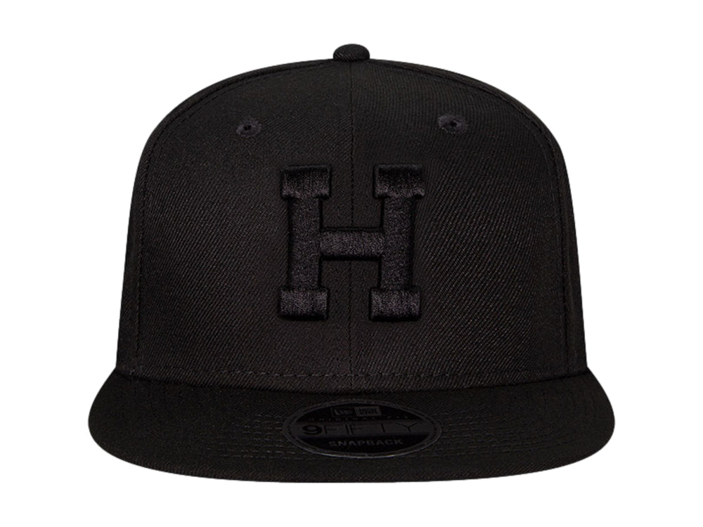Gorra de béisbol New Era color negro con visera plana y letra H bordada en relieve en el frente.