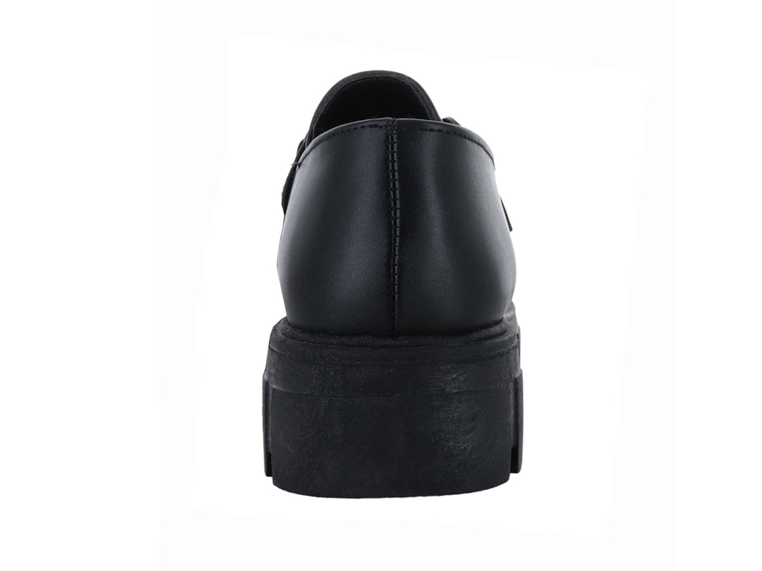 Mocasín negro con suela track gruesa y detalle de hebilla metálica.