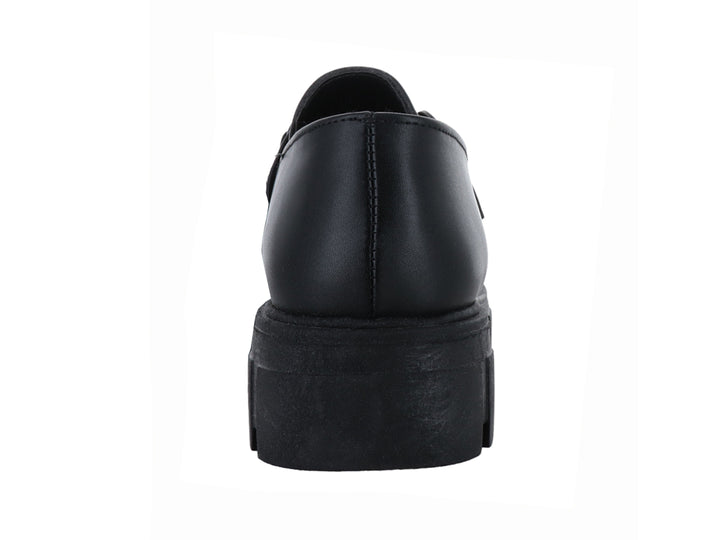 Mocasín negro con suela track gruesa y detalle de hebilla metálica.