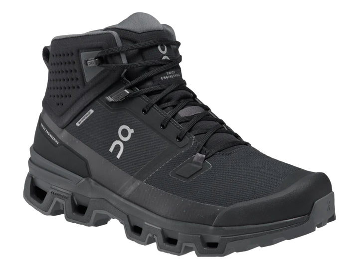 Zapato deportivo tipo botín color negro On Cloud con suela robusta y diseño impermeable.