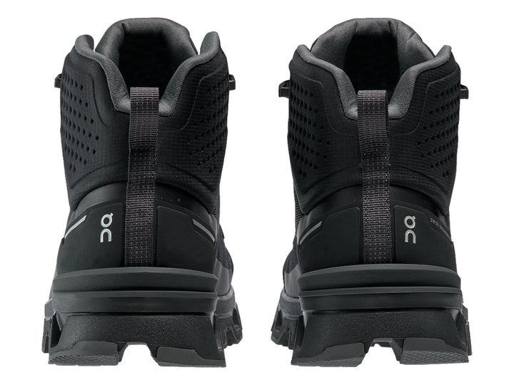 Zapato deportivo tipo botín color negro On Cloud con suela robusta y diseño impermeable.