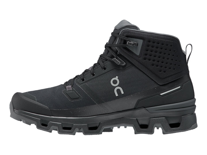 Zapato deportivo tipo botín color negro On Cloud con suela robusta y diseño impermeable.