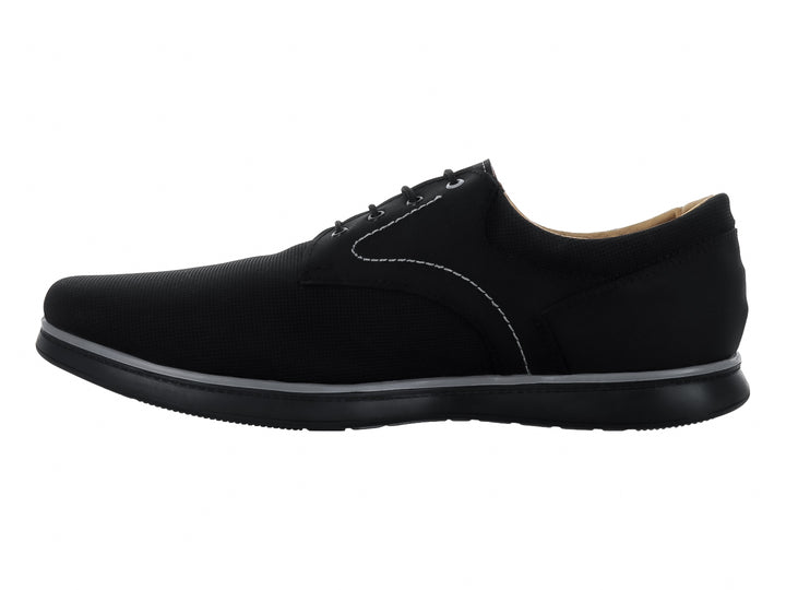 Zapato casual negro con cordones, costuras blancas y suela gris.
