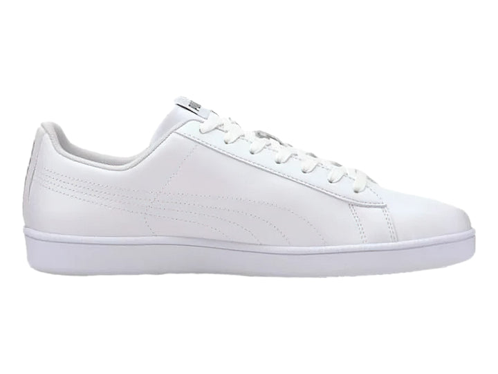 Tenis PUMA blancos de corte bajo con suela plana y cordones, estilo deportivo casual.