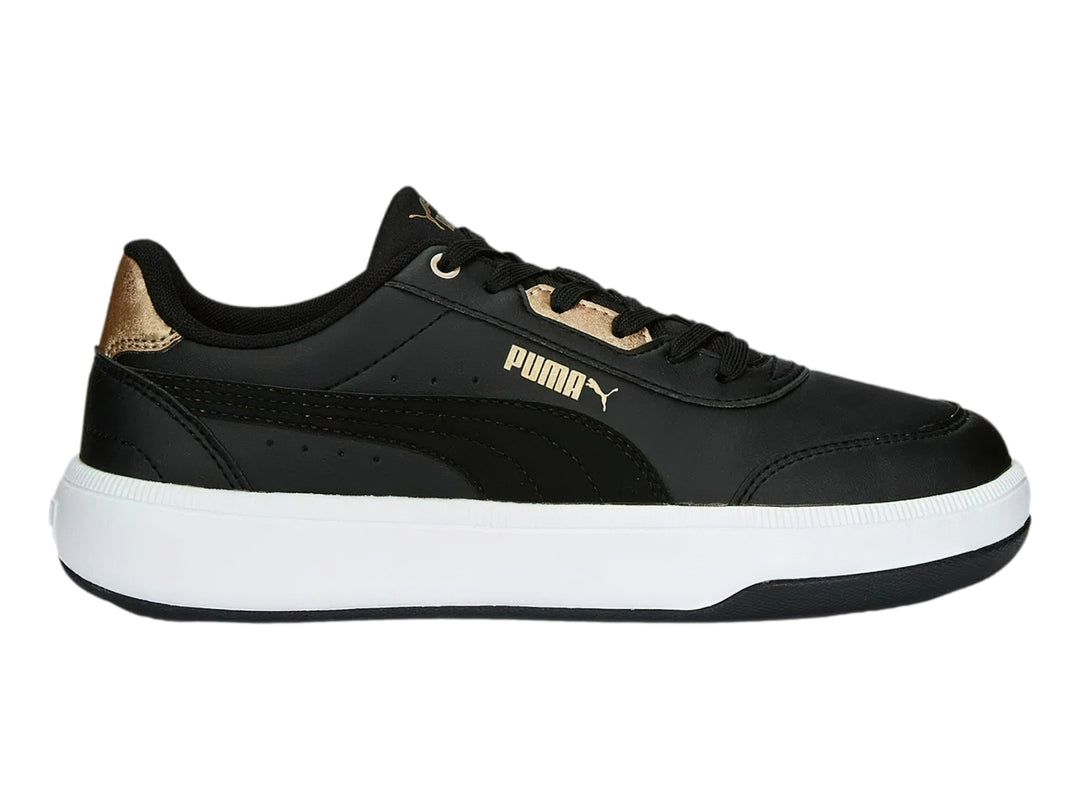 Tenis PUMA negros con suela blanca y detalles dorados en el talón y la lengüeta.
