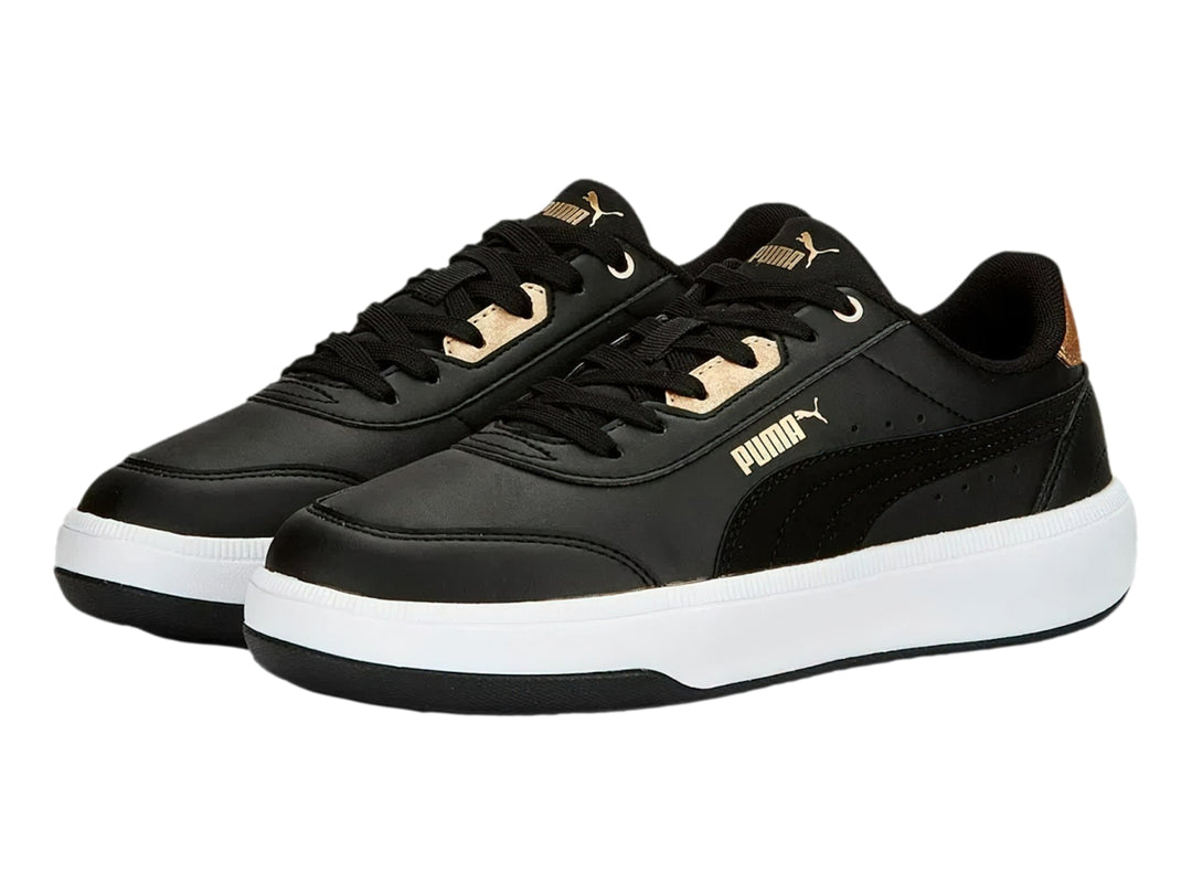 Tenis PUMA negros con suela blanca y detalles dorados en el talón y la lengüeta.