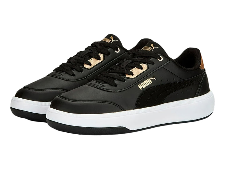 Tenis PUMA negros con suela blanca y detalles dorados en el talón y la lengüeta.