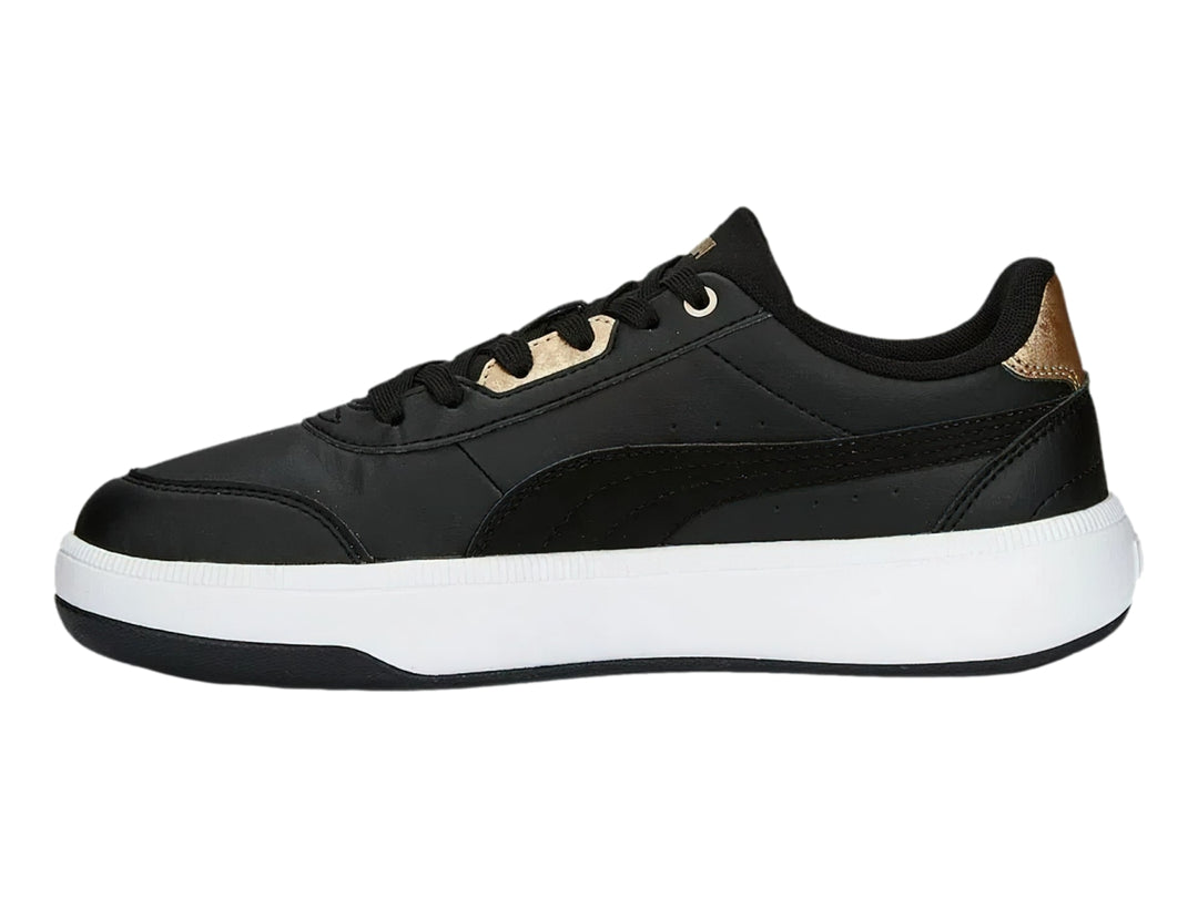 Tenis PUMA negros con suela blanca y detalles dorados en el talón y la lengüeta.