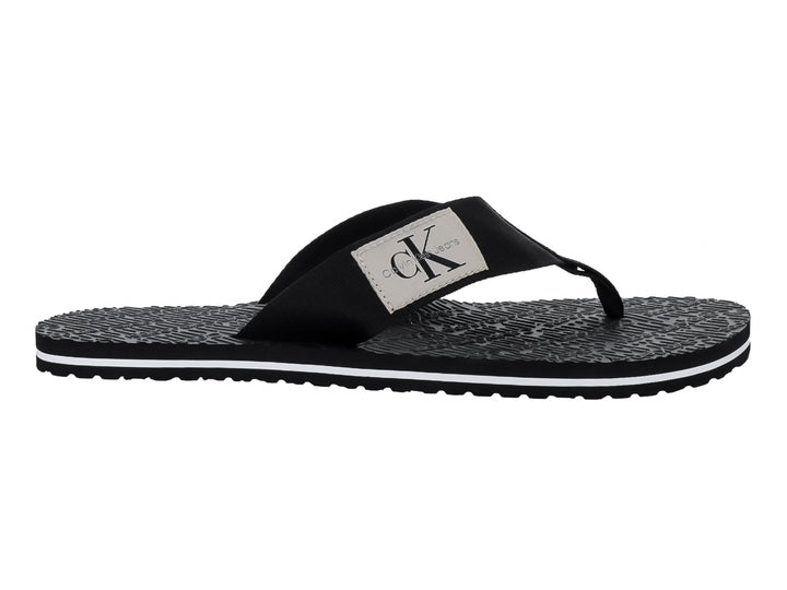 Sandalias flip-flop negras de Calvin Klein con correa de tela y suela texturizada con detalle blanco.
