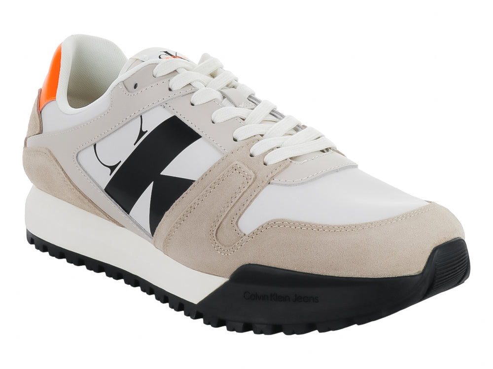 Tenis Calvin Klein multicolores en blanco, beige y negro con detalles naranjas y suela dentada negra.