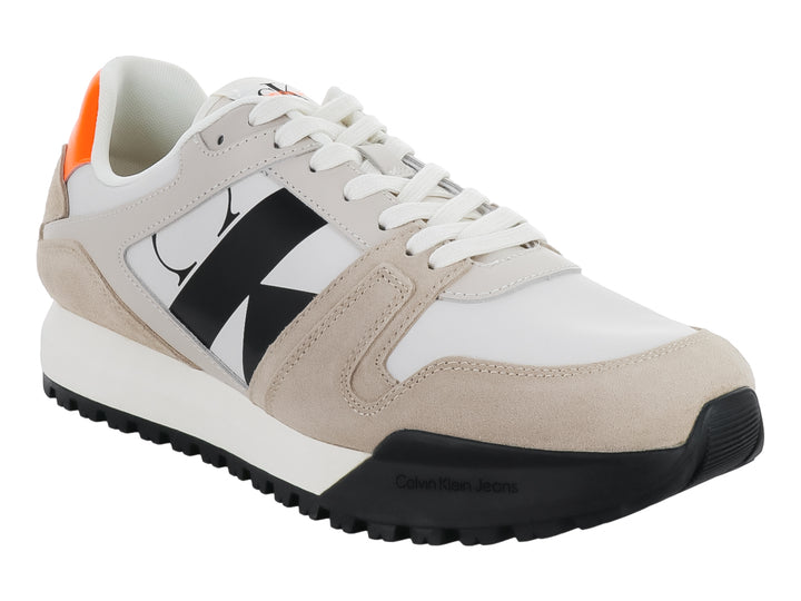 Tenis Calvin Klein multicolores en blanco, beige y negro con detalles naranjas y suela dentada negra.