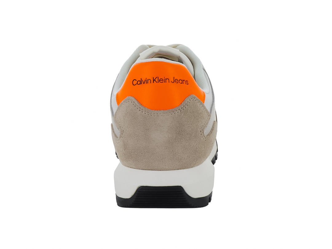 Tenis Calvin Klein multicolores en blanco, beige y negro con detalles naranjas y suela dentada negra.