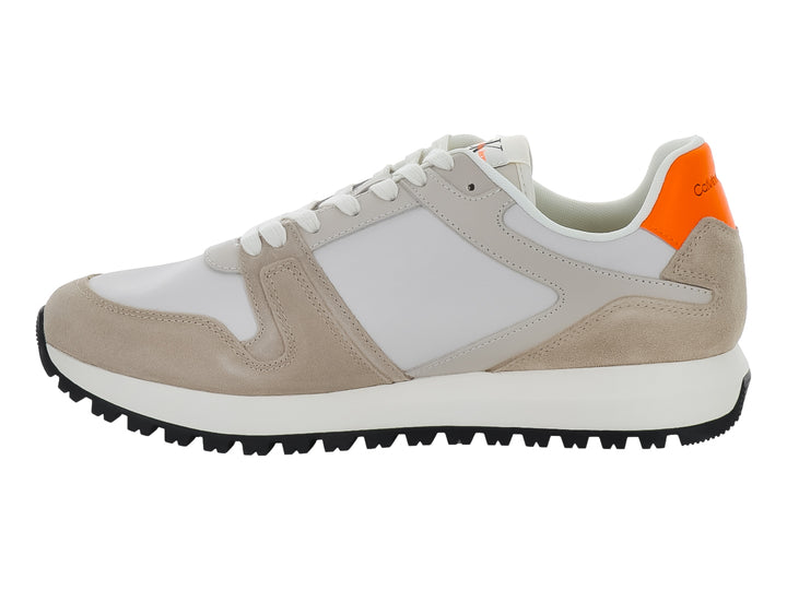 Tenis Calvin Klein multicolores en blanco, beige y negro con detalles naranjas y suela dentada negra.