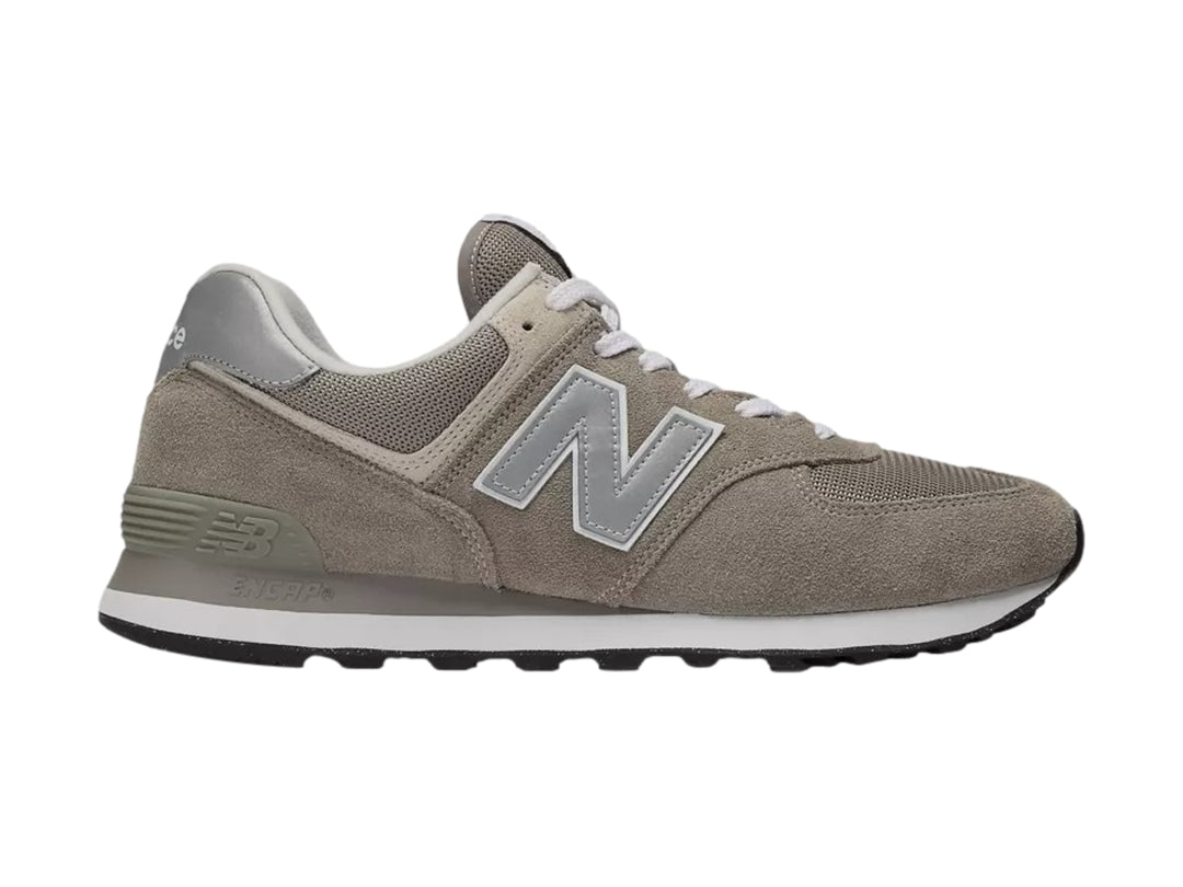 Tenis New Balance modelo 574 en color gris con detalles en blanco y suela negra.
