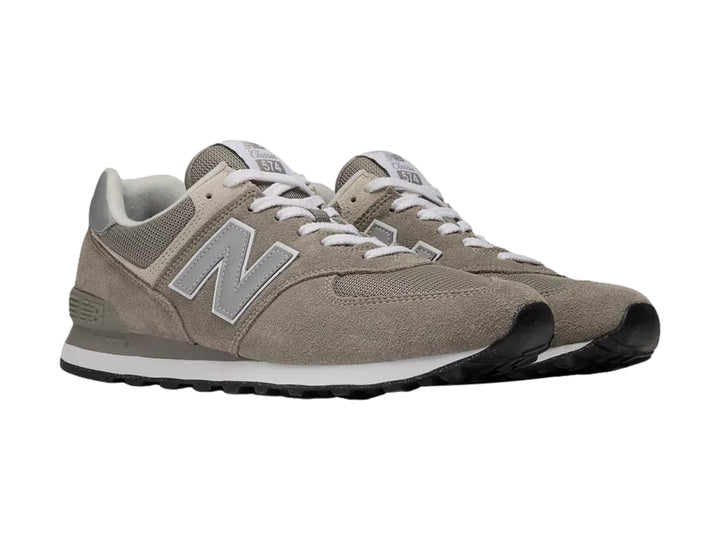 Tenis New Balance modelo 574 en color gris con detalles en blanco y suela negra.