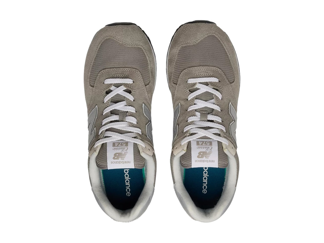 Tenis New Balance modelo 574 en color gris con detalles en blanco y suela negra.