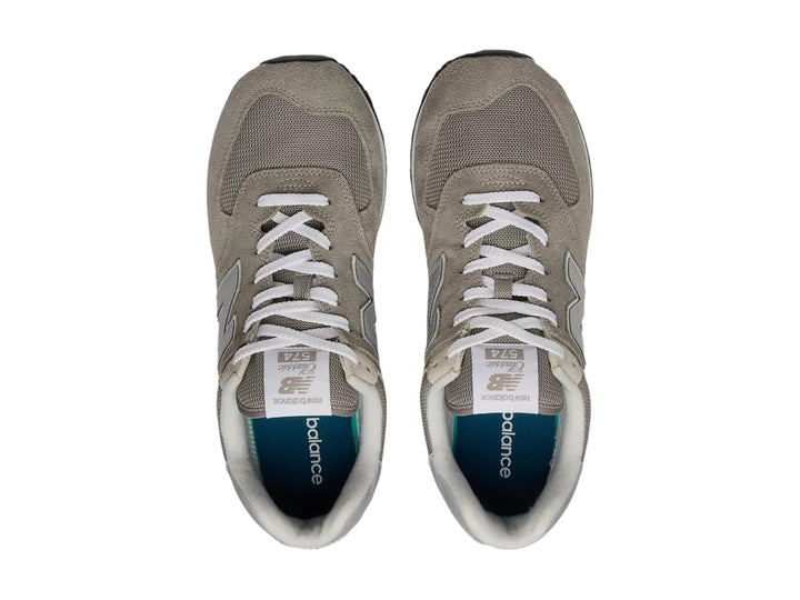 Tenis New Balance modelo 574 en color gris con detalles en blanco y suela negra.