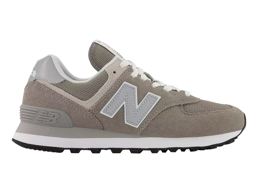 Tenis New Balance modelo 574 en color gris con detalles en blanco y suela blanca.