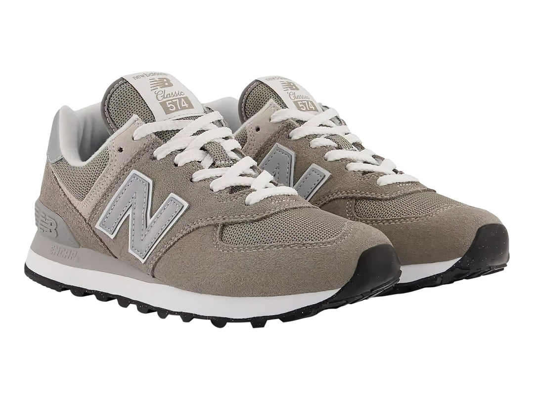 Tenis New Balance modelo 574 en color gris con detalles en blanco y suela blanca.