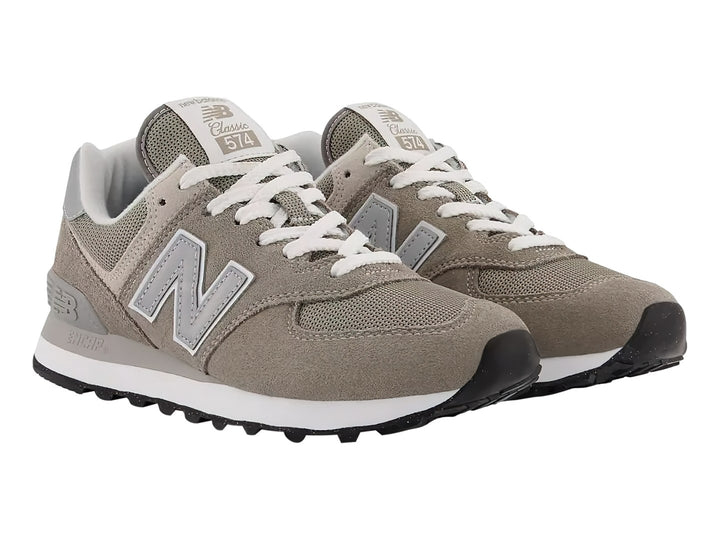 Tenis New Balance modelo 574 en color gris con detalles en blanco y suela blanca.