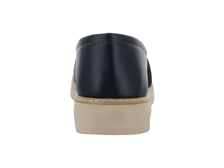 Zapato tipo mocasín color negro con suela gruesa beige y detalle metálico dorado en la parte superior.