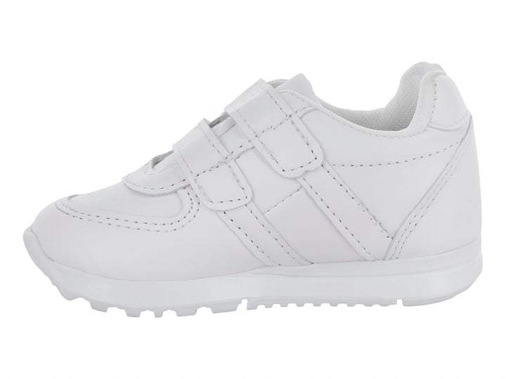 Zapato escolar blanco para niño con cierre de velcro y suela blanca.