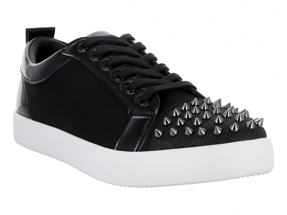 Tenis negros con detalles en charol, suela blanca y estoperoles en la punta.