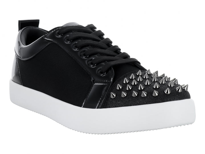 Tenis negros con detalles en charol, suela blanca y estoperoles en la punta.