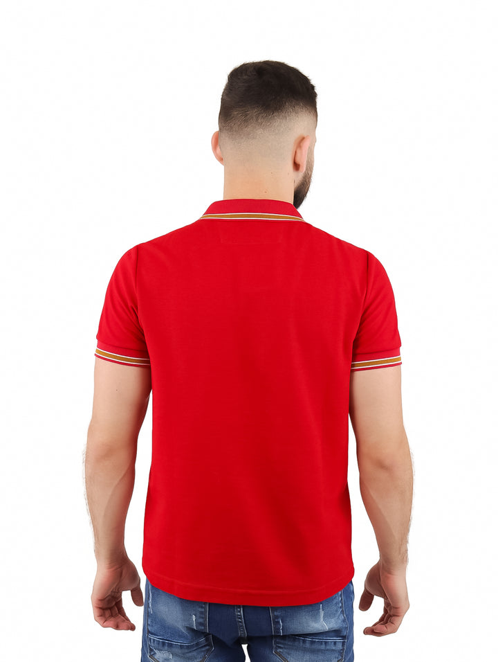 Hombre vistiendo playera polo roja con cierre frontal y detalles en color café en el cuello y mangas.