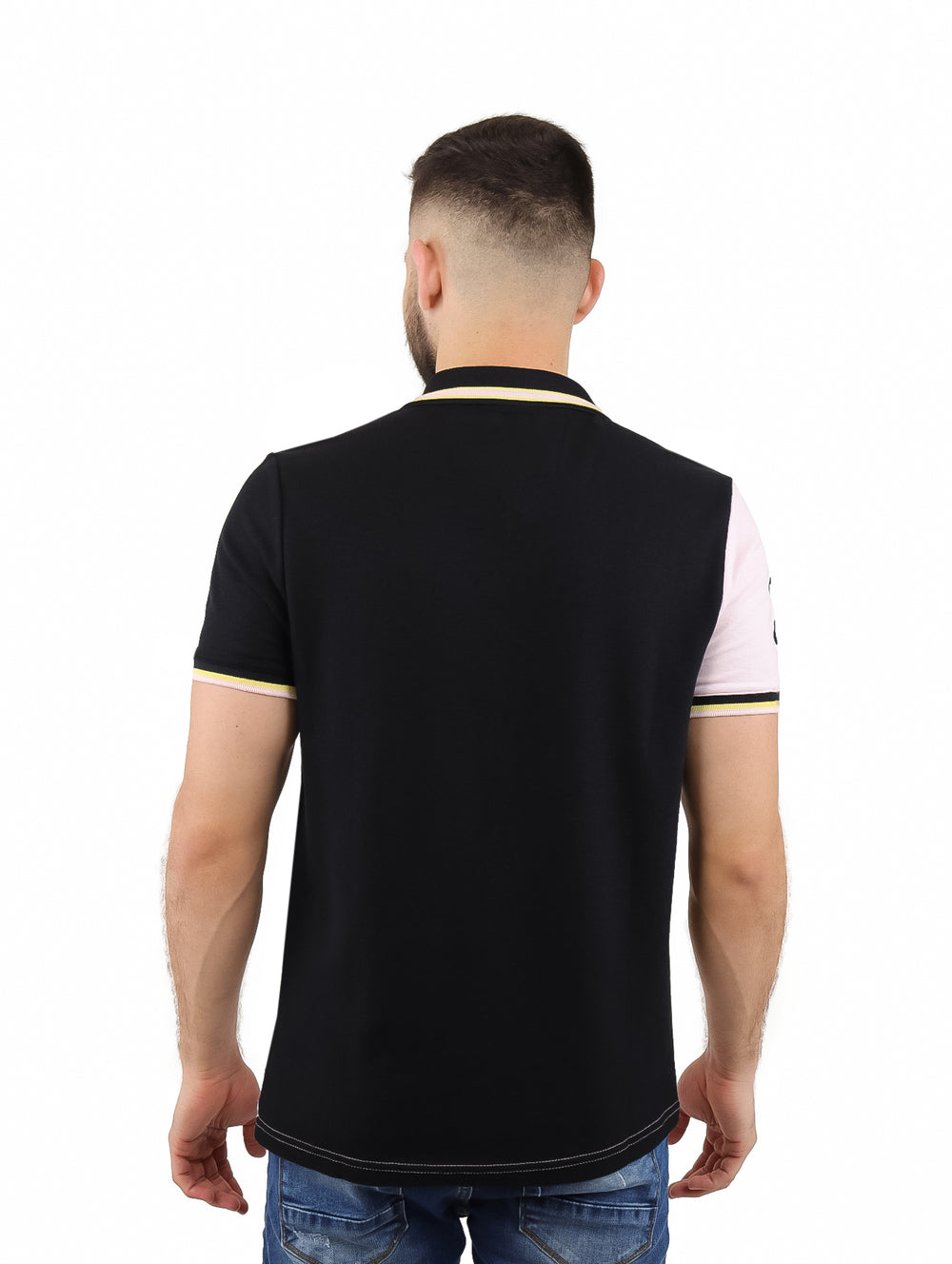 Hombre vistiendo playera polo de manga corta con diseño diagonal en colores rosa, blanco y negro.