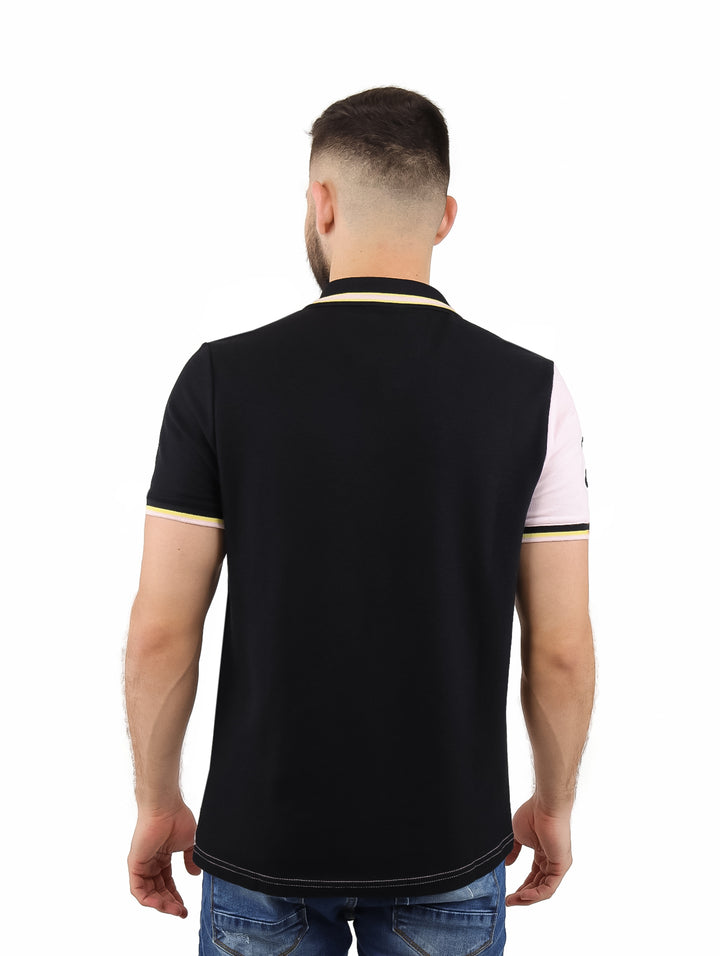 Hombre vistiendo playera polo de manga corta con diseño diagonal en colores rosa, blanco y negro.
