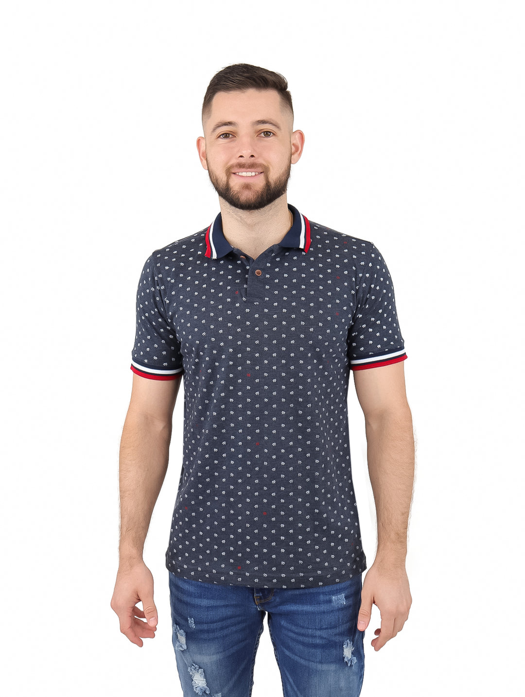 Hombre vistiendo playera polo gris oscuro con estampado pequeño y ribetes rojos y blancos en cuello y mangas.