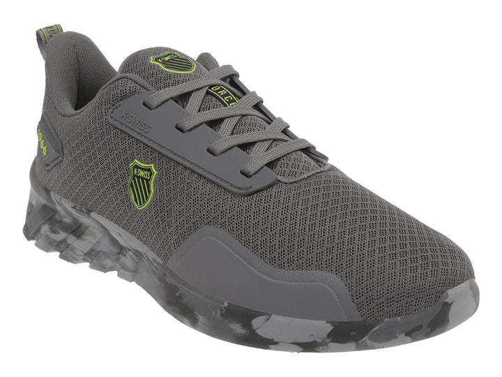 Tenis deportivos K-Swiss color gris con suela en patrón de camuflaje y logotipo amarillo lateral.