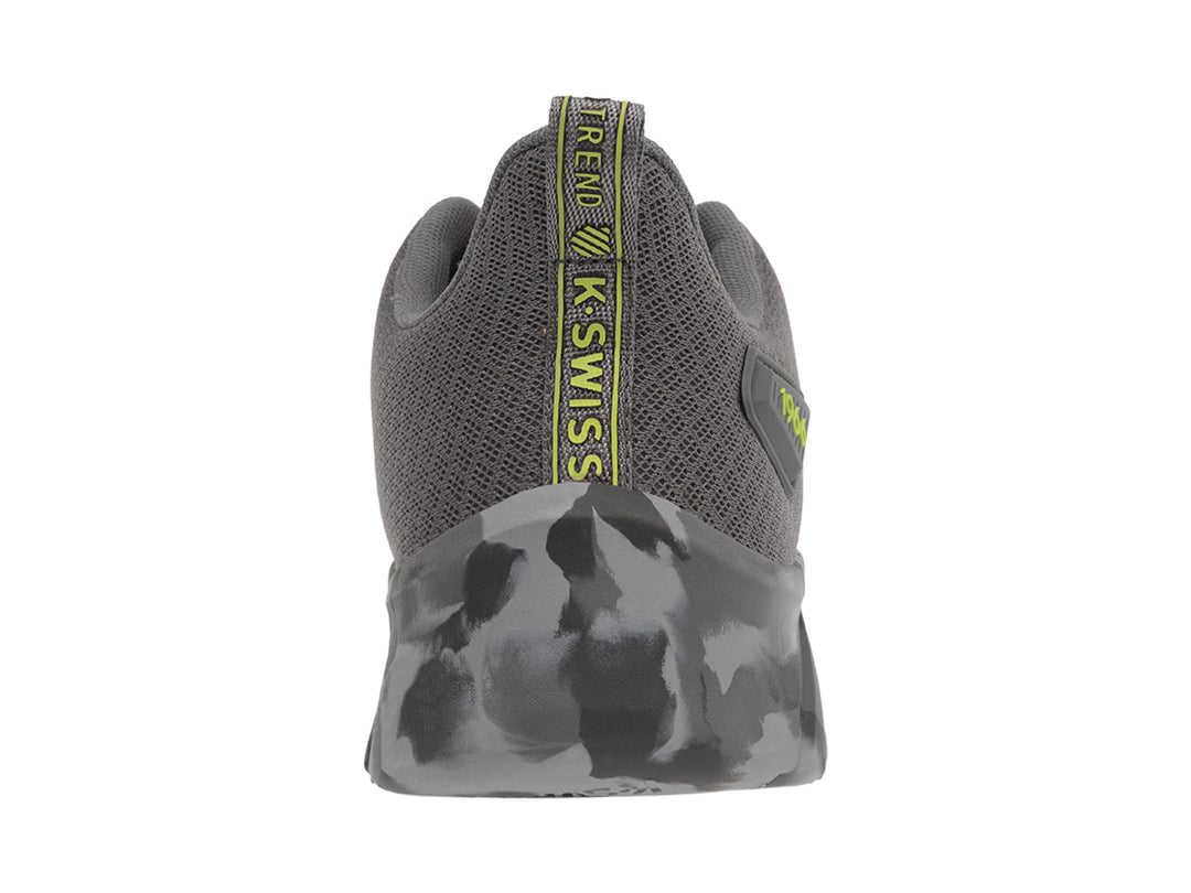 Tenis deportivos K-Swiss color gris con suela en patrón de camuflaje y logotipo amarillo lateral.