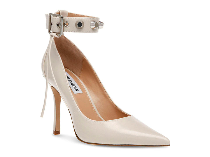 Zapato de tacón stiletto color hueso con punta fina y correa al tobillo decorada con tachuelas.
