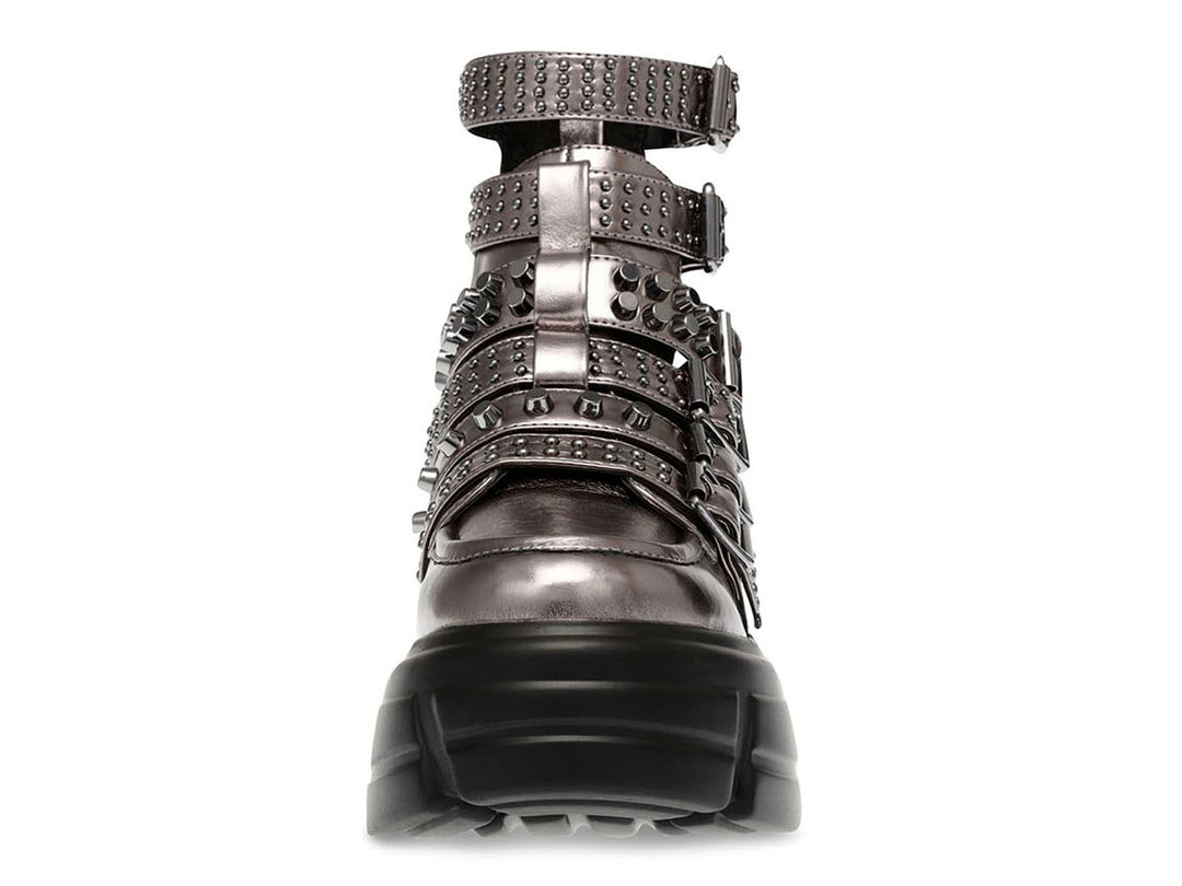 Botín Steve Madden color pewter con plataforma negra, múltiples correas con hebillas y estoperoles.