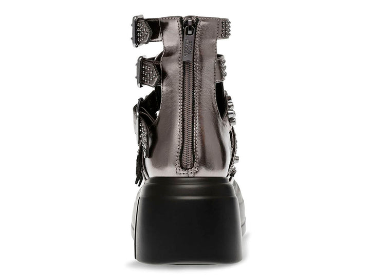 Botín Steve Madden color pewter con plataforma negra, múltiples correas con hebillas y estoperoles.