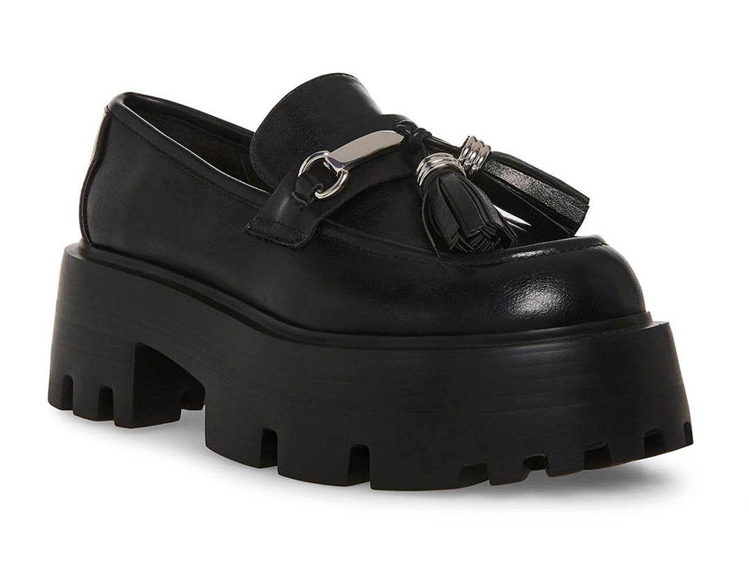 Zapato mocasín Steve Madden color negro con plataforma gruesa, suela track y detalle de borlas con herraje plateado.