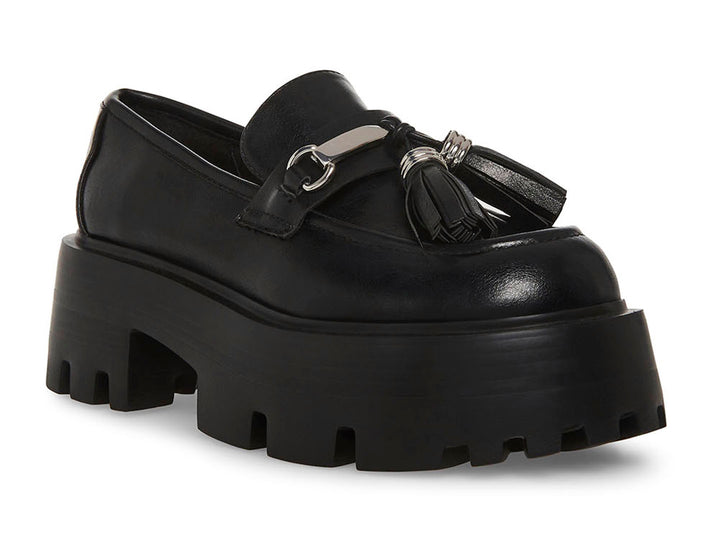 Zapato mocasín Steve Madden color negro con plataforma gruesa, suela track y detalle de borlas con herraje plateado.
