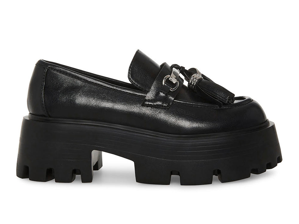 Zapato mocasín Steve Madden color negro con plataforma gruesa, suela track y detalle de borlas con herraje plateado.