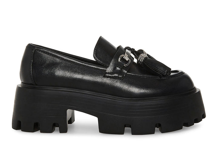 Zapato mocasín Steve Madden color negro con plataforma gruesa, suela track y detalle de borlas con herraje plateado.