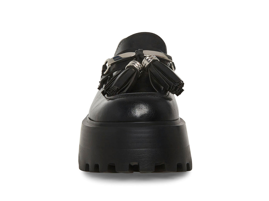 Zapato mocasín Steve Madden color negro con plataforma gruesa, suela track y detalle de borlas con herraje plateado.