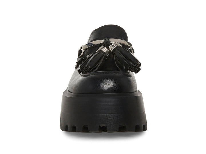 Zapato mocasín Steve Madden color negro con plataforma gruesa, suela track y detalle de borlas con herraje plateado.
