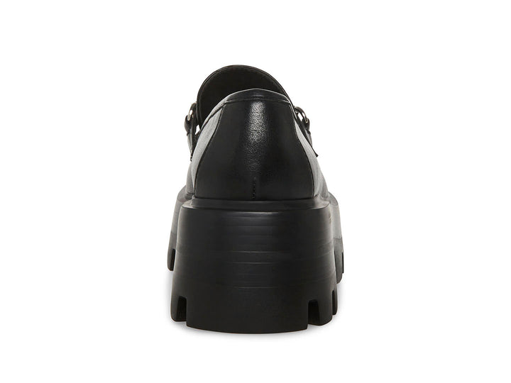 Zapato mocasín Steve Madden color negro con plataforma gruesa, suela track y detalle de borlas con herraje plateado.