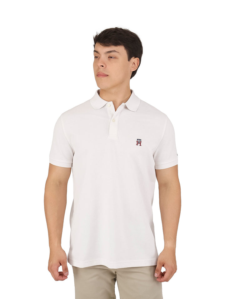 Hombre vistiendo una playera polo de color beige de manga corta con un pequeño logo en el pecho.