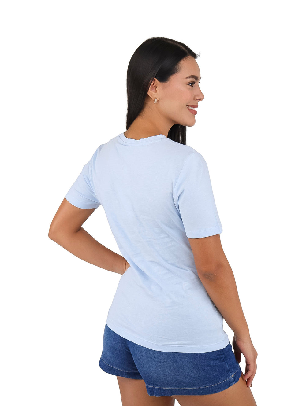 Mujer vistiendo playera azul claro de manga corta con la palabra HILFIGER en el pecho.
