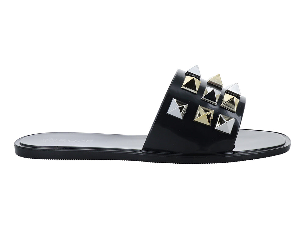 Sandalia slide negra con tachuelas metálicas en forma de pirámide doradas y plateadas.