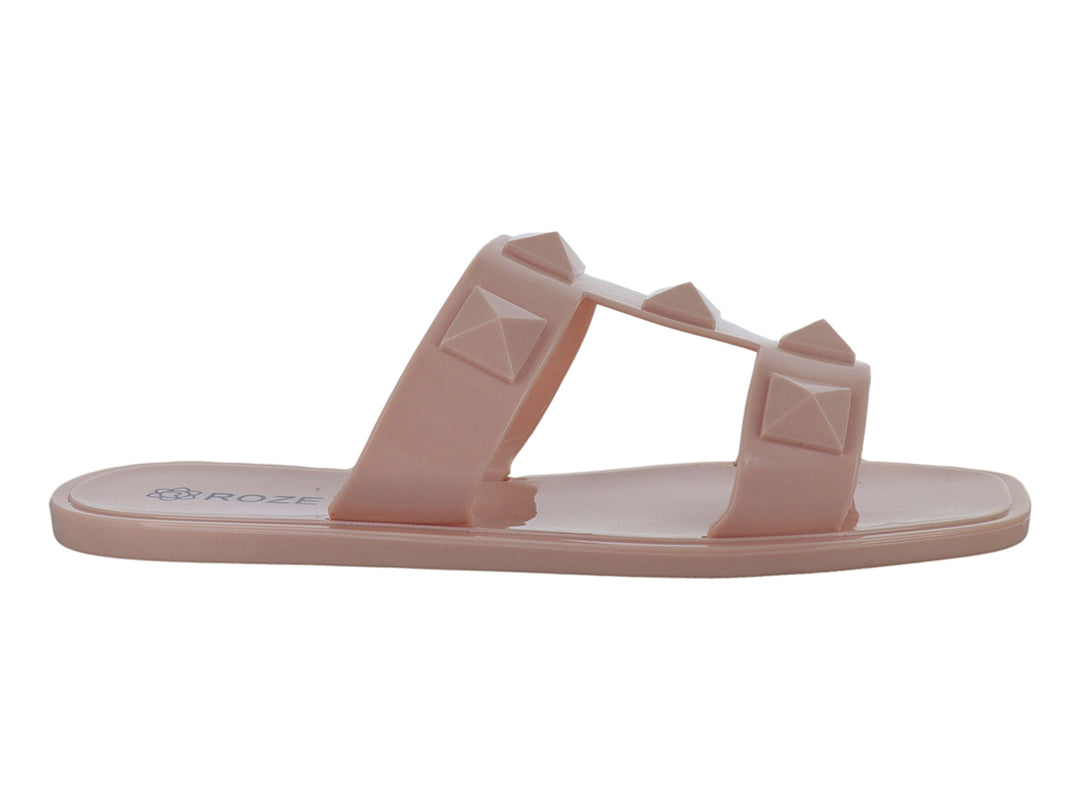 Sandalias color nude para niña con dos tiras decoradas con tachuelas piramidales en relieve.