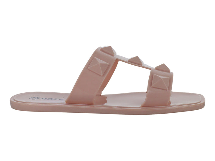 Sandalias color nude para niña con dos tiras decoradas con tachuelas piramidales en relieve.