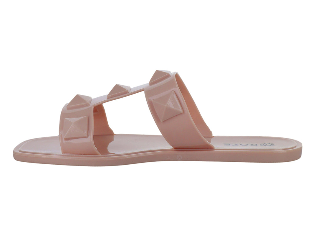 Sandalias color nude para niña con dos tiras decoradas con tachuelas piramidales en relieve.